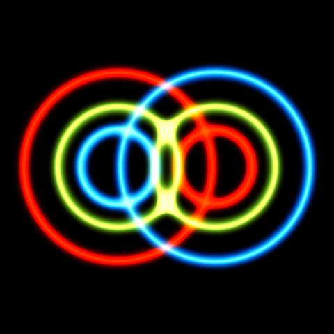 A visual representation of quantum entanglement, showing two sets of concentric rings interfering with each other, in yellows, blues and reds on a black background.